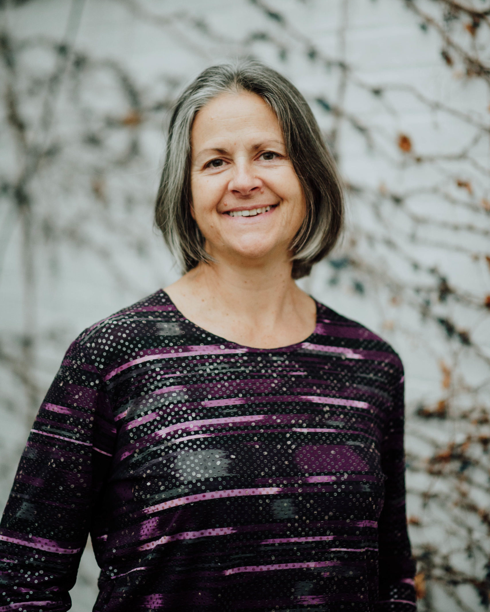 Photo of Nancy Heiz smiling outside.